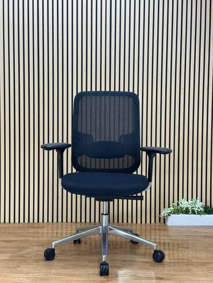 Orangebox Do ergonomic office chair black mesh back with adjustable arms and lumbar support in front of wood slat wall.