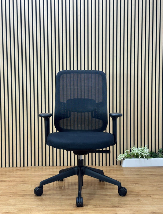 Orangebox Do ergonomic office chair black mesh back with adjustable arms and lumbar support in front of wood slat wall.
