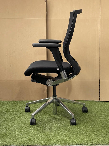 Black office chair on a green surface with a brown cardboard background techo t50