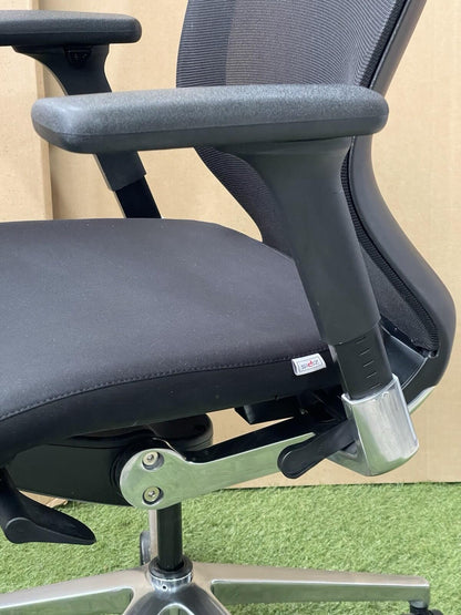 Close-up of an office chair with a focus on the armrest and base.